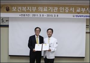 전남대병원 류종선 진료처장(사진 오른쪽)이 송은규 원장을 대신해 이규식 보건복지부 의료기관인증평가원장으로부터 ‘의료기관 인증서’를 교부받았다.